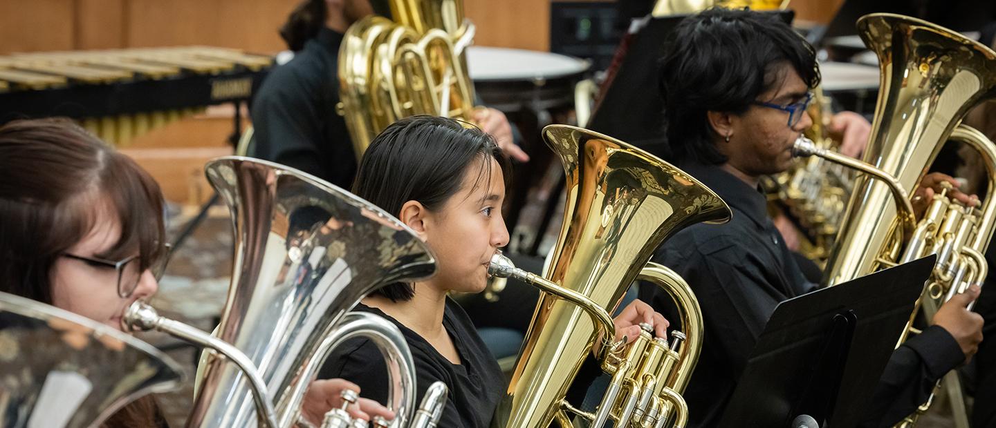 Musicians playing brass instruments in an ensemble.